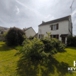 Maison avec jardin et ciel nuageux