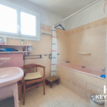 Salle de bain ancienne avec baignoire et fenêtre.