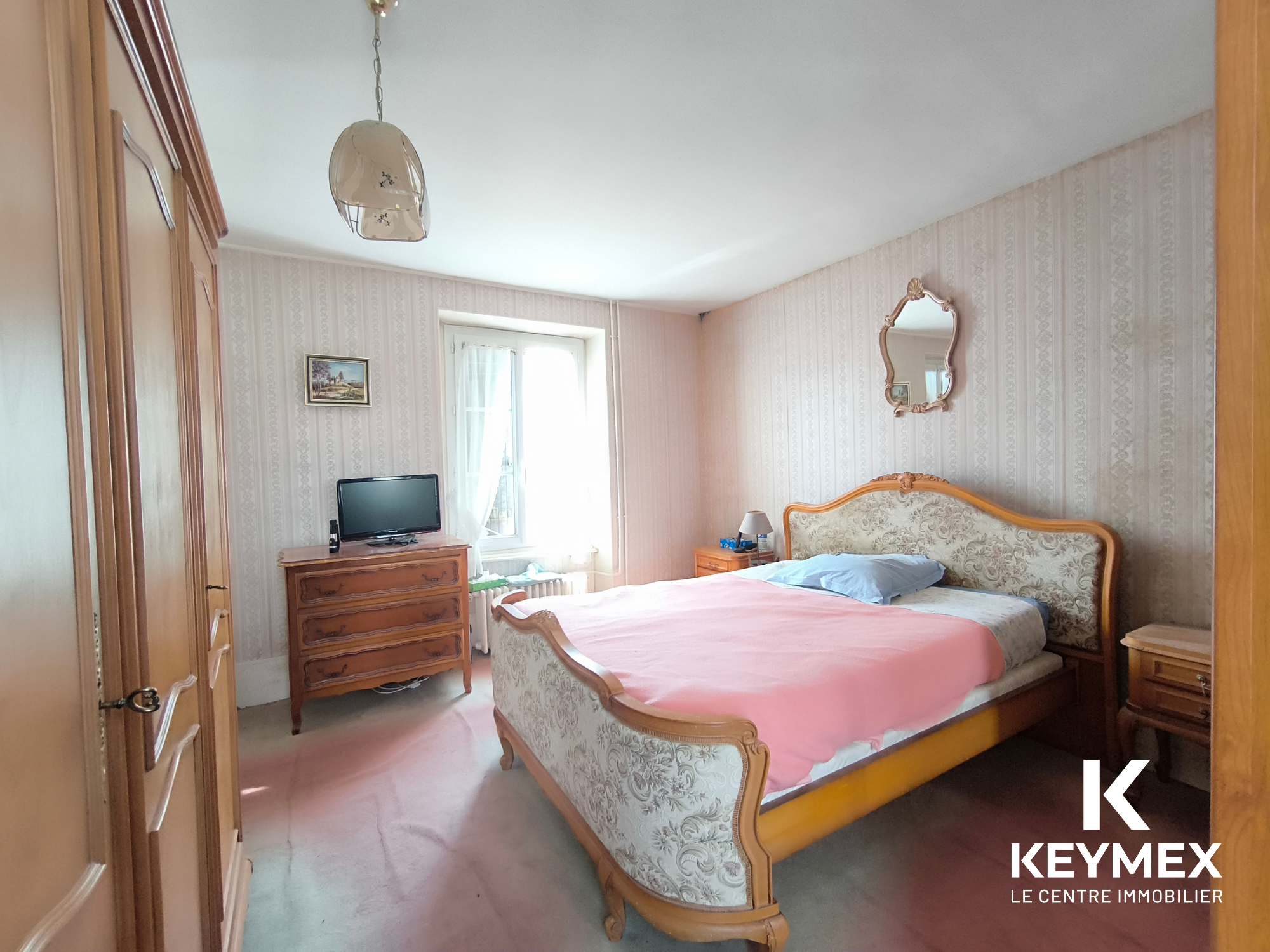Chambre double avec armoire et télévision.