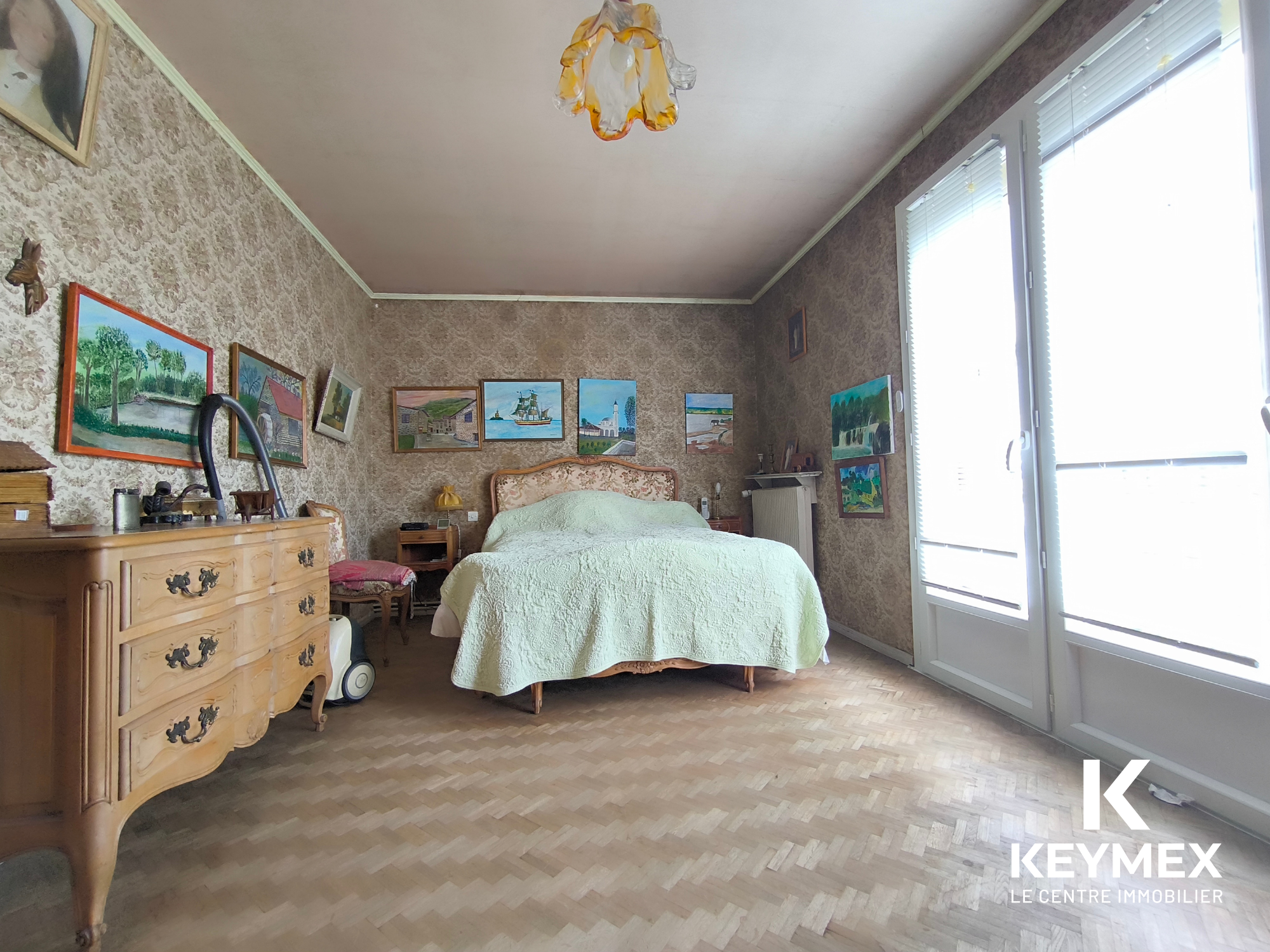 Chambre avec lit ancien, parquet et peintures murales.