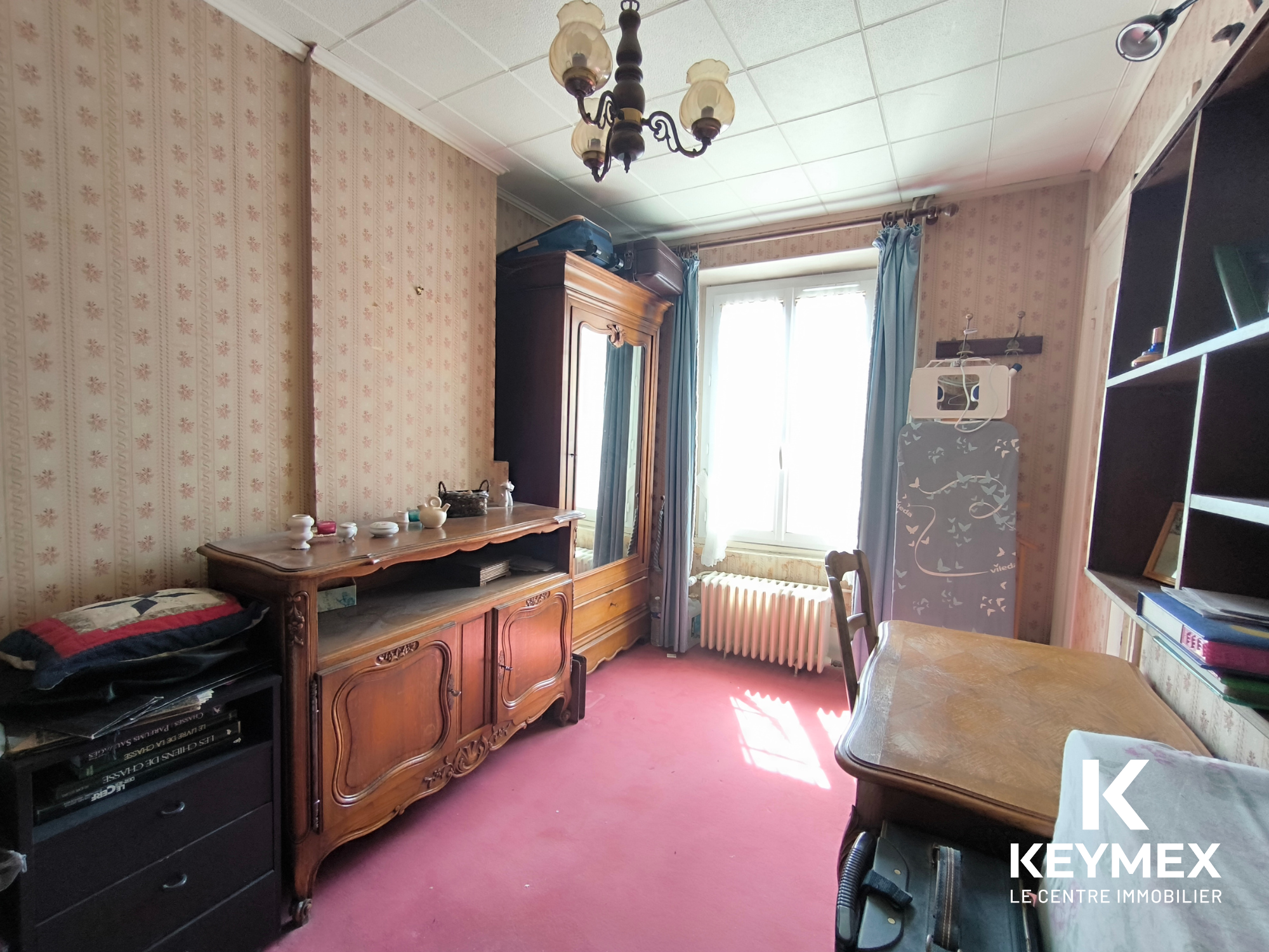 Chambre vintage avec armoire et bureau en bois.