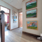 Maison avec escalier en bois et peintures murales.