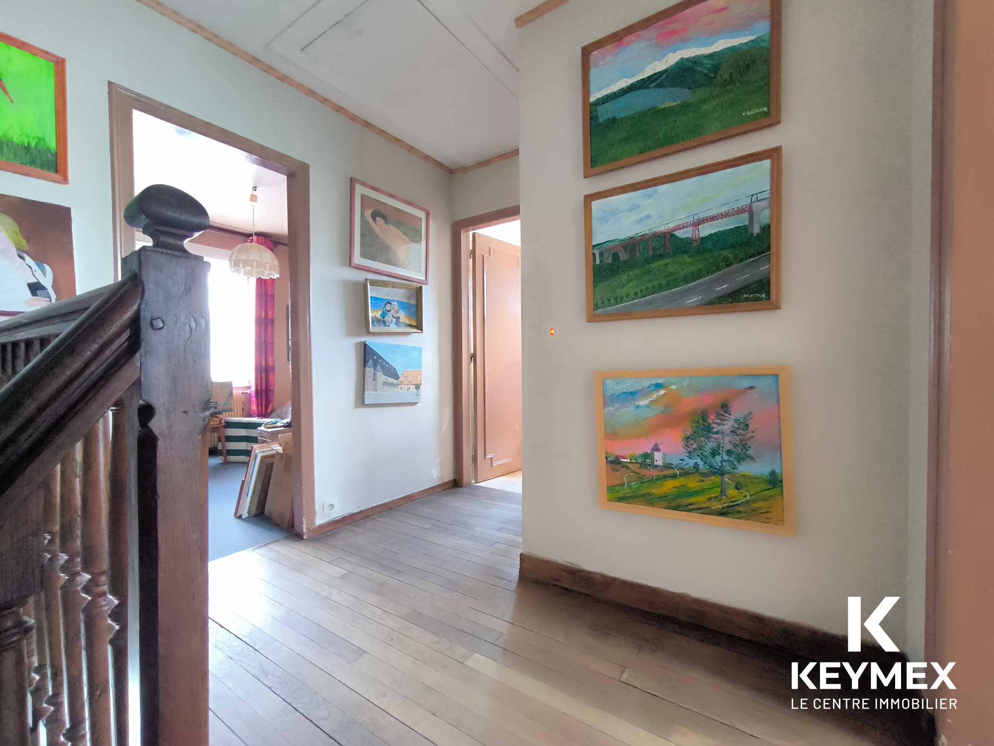 Maison avec escalier en bois et peintures murales.