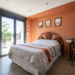 Chambre lumineuse avec lit et balcon.