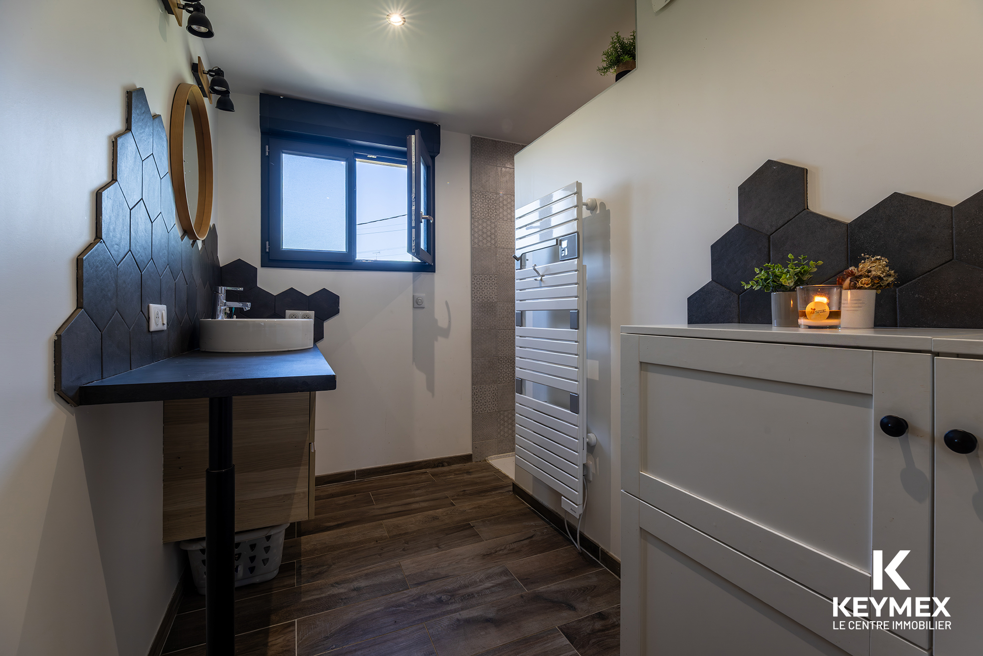 Salle de bain moderne avec carrelage hexagonal noir.