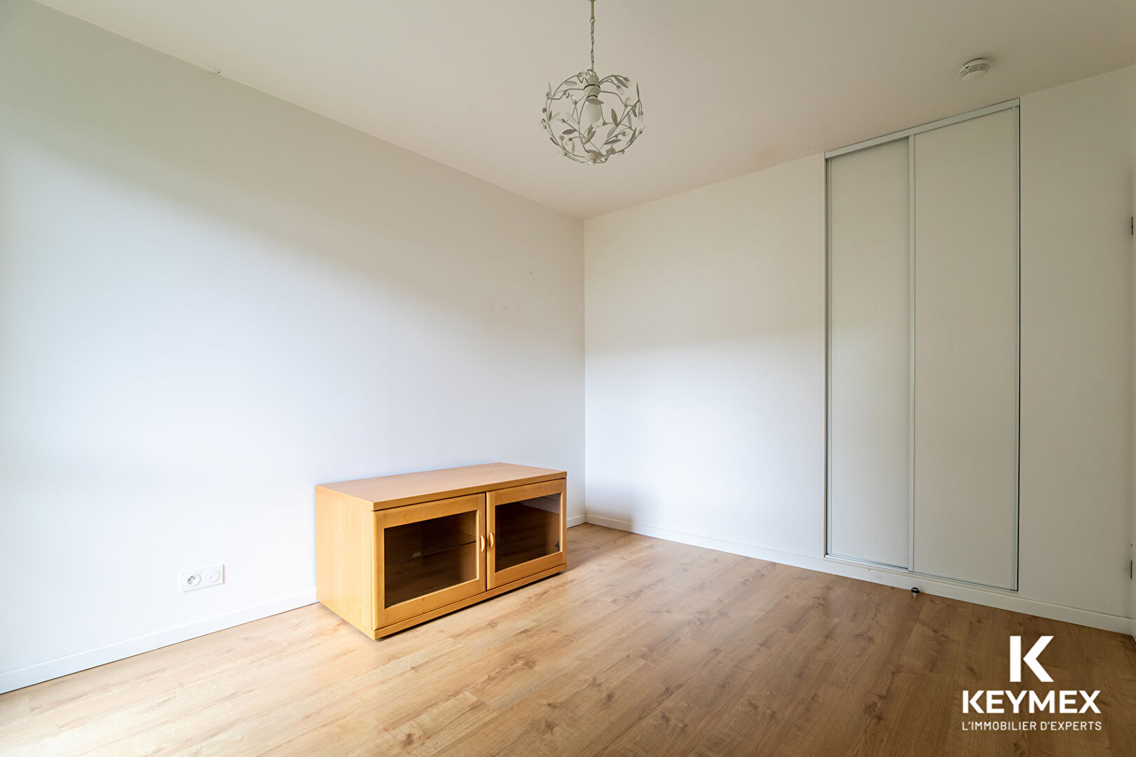 Chambre vide avec placard et meuble en bois.
