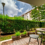 Terrasse avec mobilier de jardin, verdure environnante.
