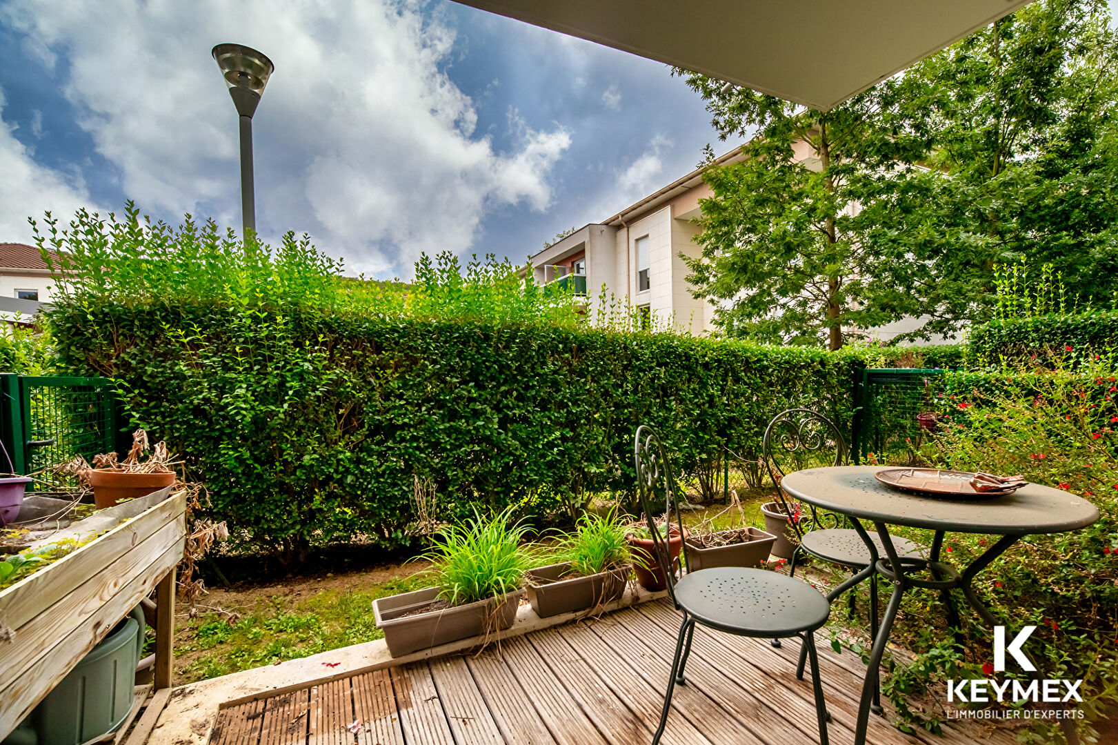 Terrasse avec mobilier de jardin, verdure environnante.