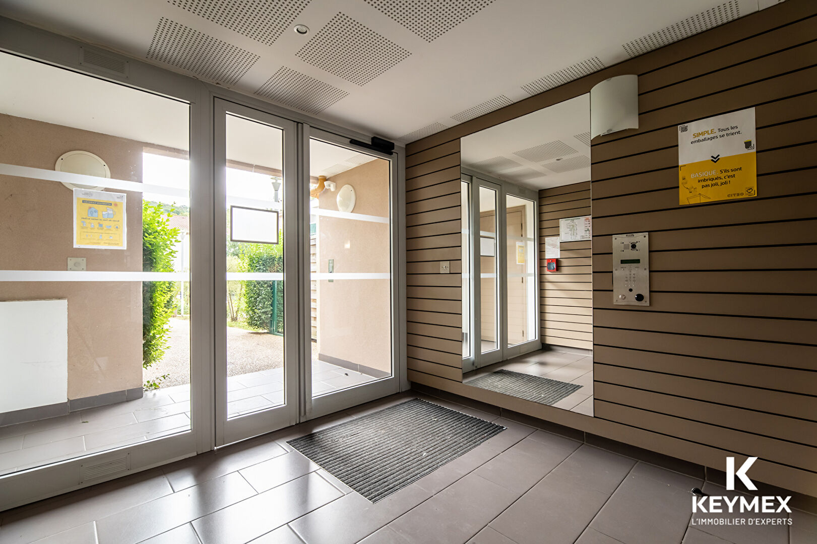 Entrée d'immeuble moderne avec interphone.