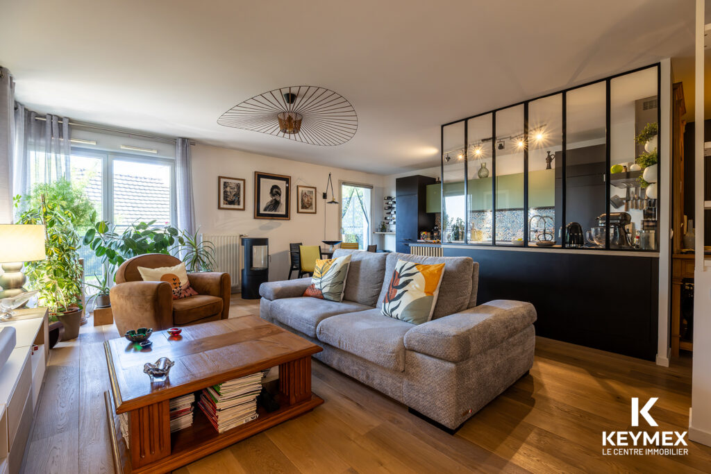 Salon moderne avec cuisine ouverte et décoration élégante.