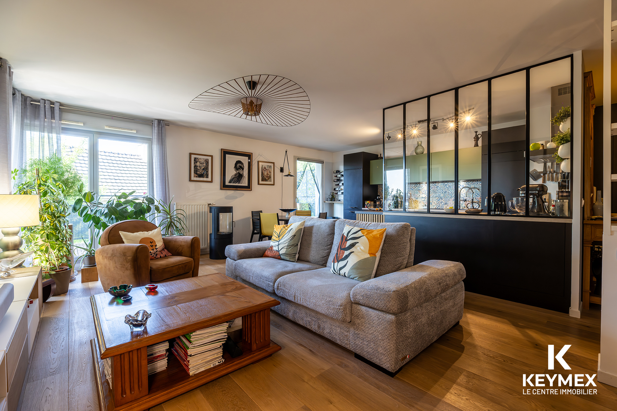 Salon moderne avec cuisine ouverte et décoration élégante.