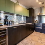 Cuisine moderne avec carreaux colorés et électroménager.