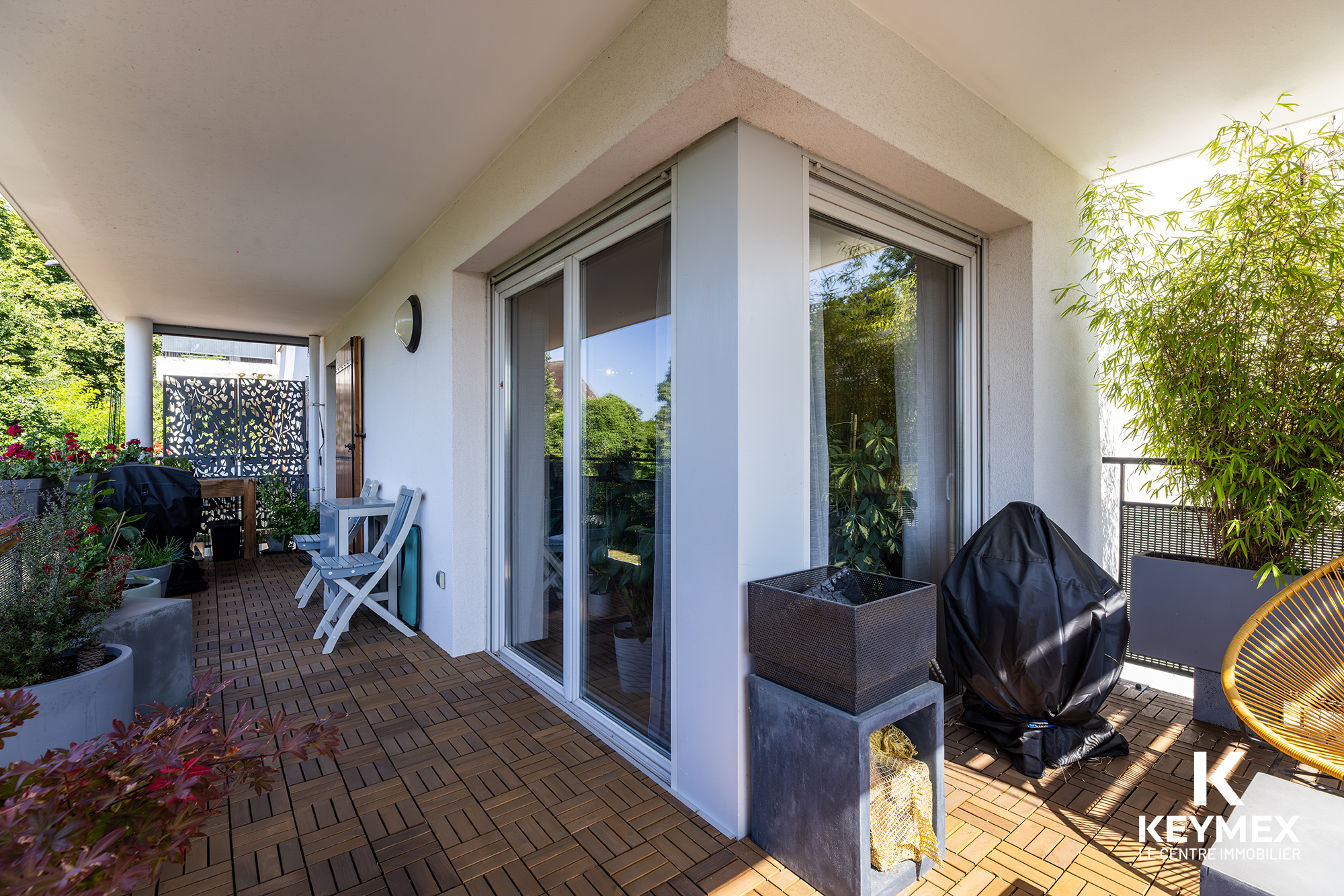 Balcon moderne avec mobilier et végétation luxuriante.