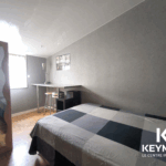 Chambre moderne avec lit et bureau lumineux.