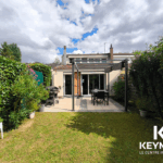 Jardin avec terrasse et mobilier d'extérieur.