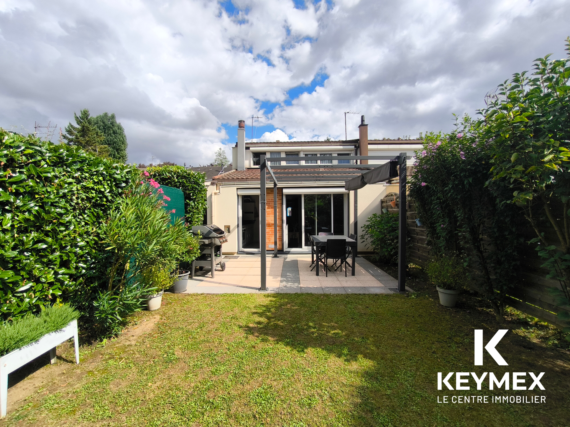 Jardin avec terrasse et mobilier d'extérieur.