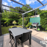 Terrasse avec table et barbecue extérieur.
