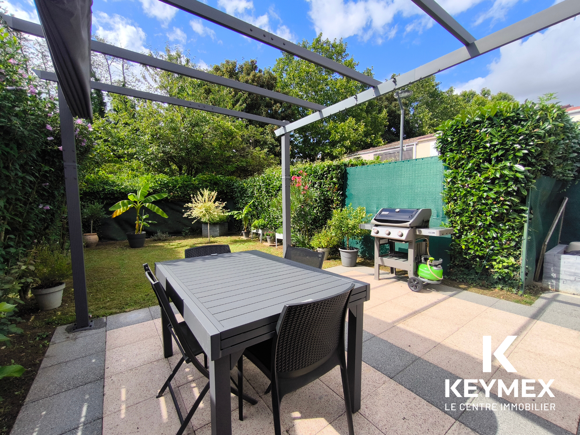 Terrasse avec table et barbecue extérieur.