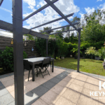 Terrasse avec pergola et jardin verdoyant