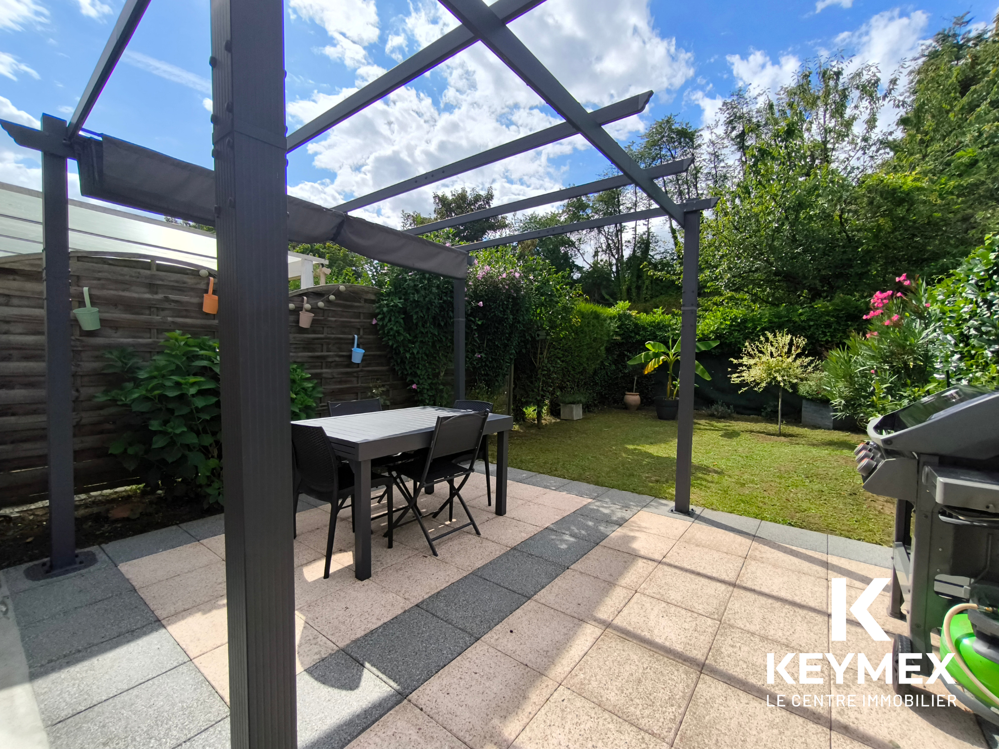 Terrasse avec pergola et jardin verdoyant