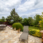 Terrasse jardin avec mobilier extérieur et plantes.