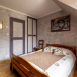 Chambre avec lit en bois et décoration murale.