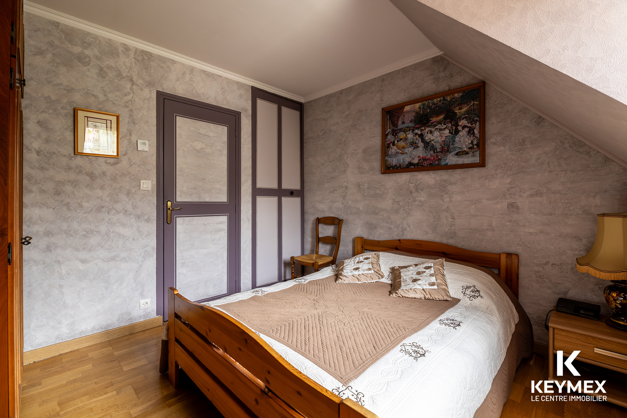Chambre avec lit en bois et décoration murale.