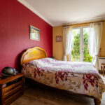 Chambre lumineuse avec lit double en bois.