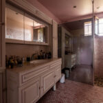 Salle de bain moderne avec carrelage rose et miroirs.