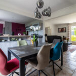 Salon moderne avec chaises colorées et orchidée blanche.