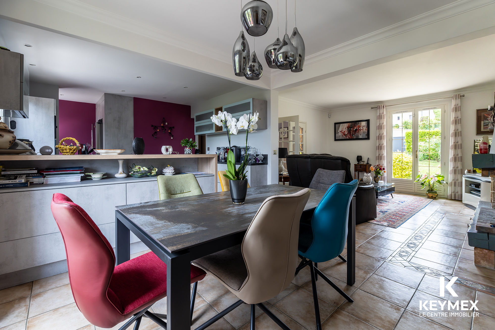 Salon moderne avec chaises colorées et orchidée blanche.