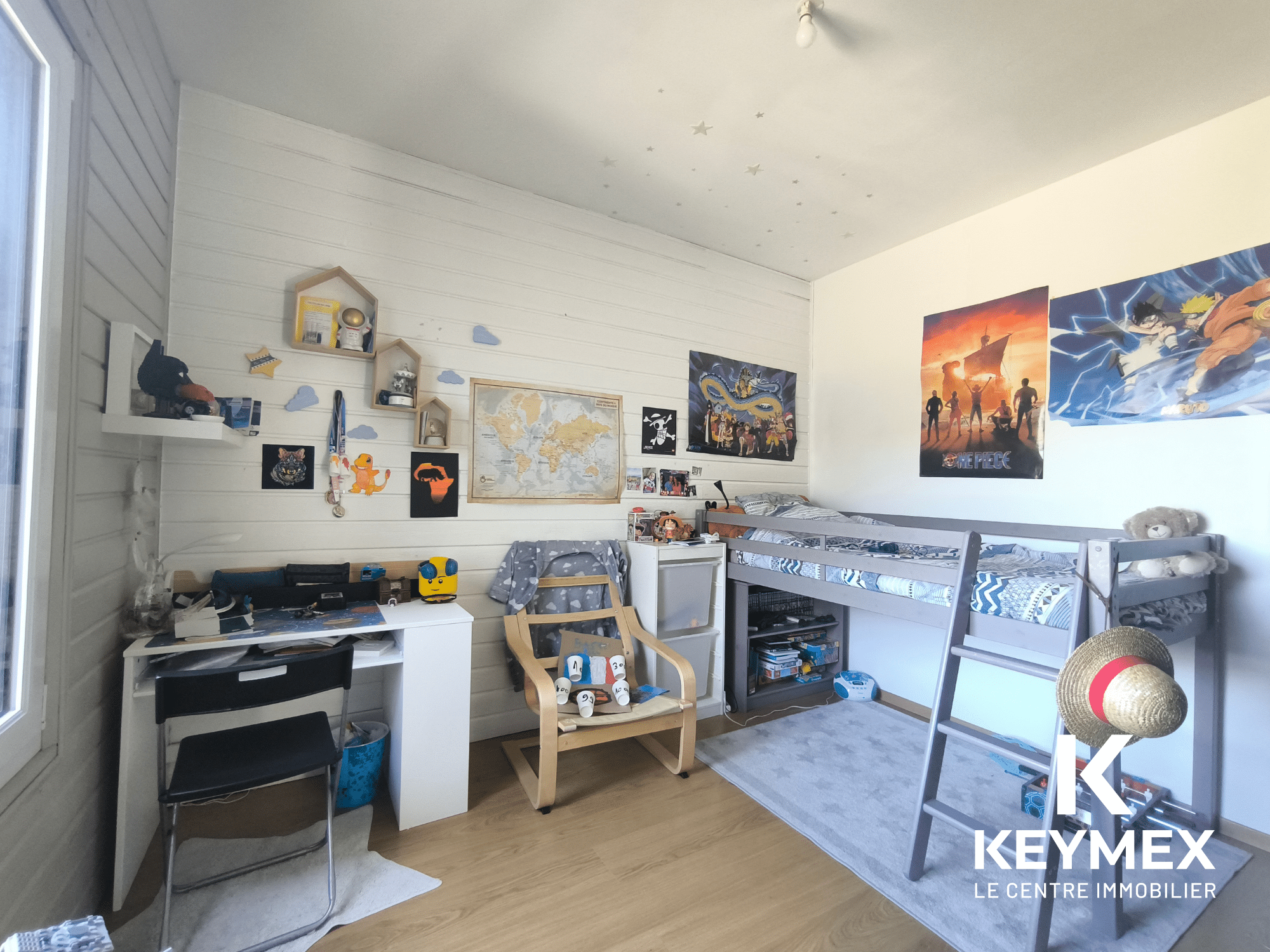Chambre d'enfant avec lit superposé et décorations murales.