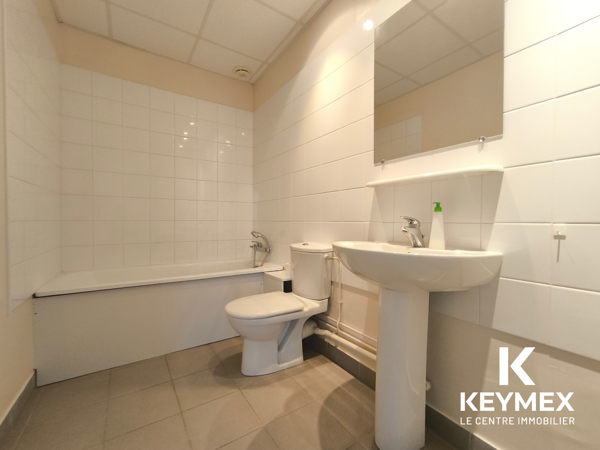 Salle de bain moderne avec baignoire et lavabo.