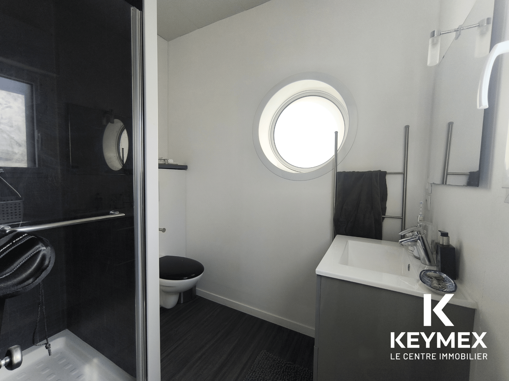 Salle de bain moderne avec douche et lavabo.