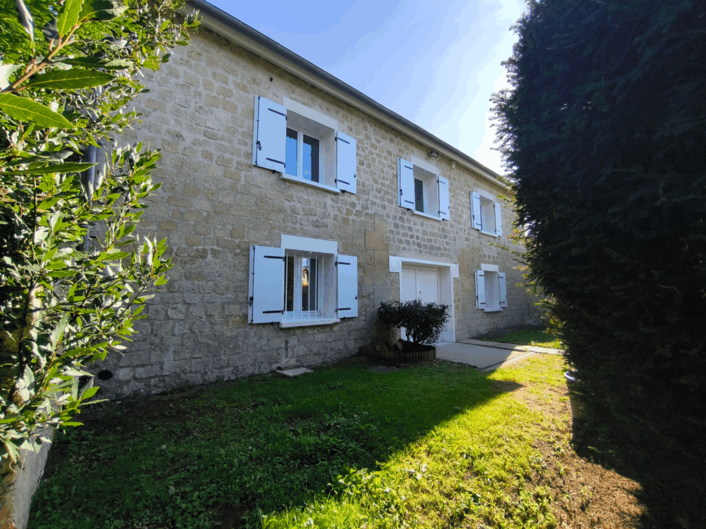 Maison en pierre avec volets blancs ouverte au soleil