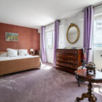 Chambre élégante avec mobilier ancien et vue extérieure.