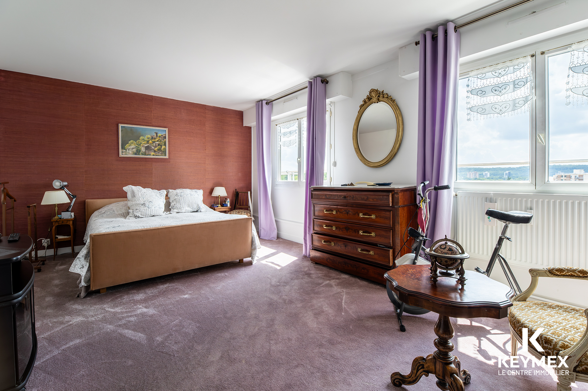 Chambre élégante avec mobilier ancien et vue extérieure.