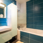 Salle de bain moderne avec baignoire et lavabo.
