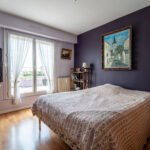 Chambre lumineuse avec accès terrasse et décoration élégante.