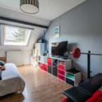 Chambre sous toit avec équipements sportifs et jouets.