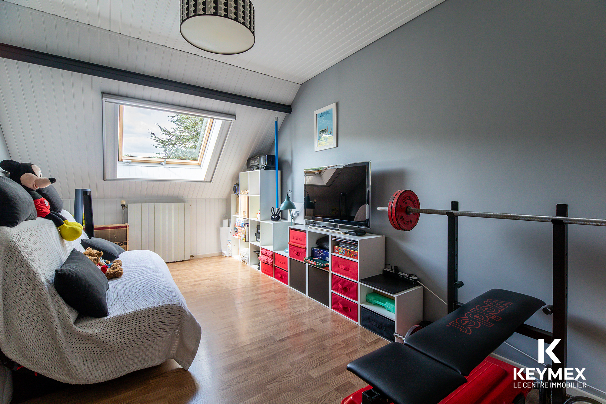 Chambre sous toit avec équipements sportifs et jouets.
