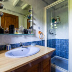 Salle de bain moderne avec douche et lavabo.