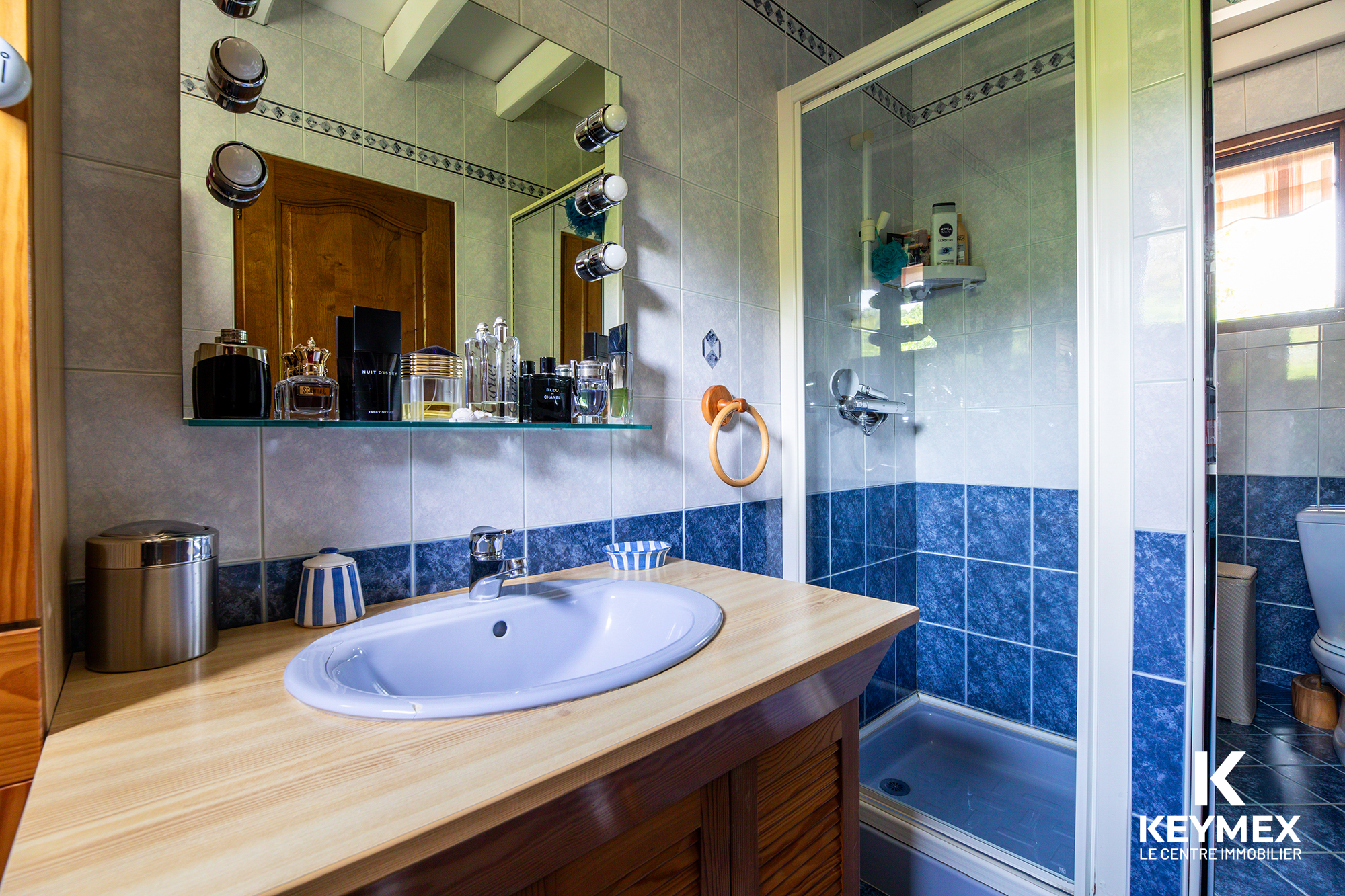 Salle de bain moderne avec douche et lavabo.