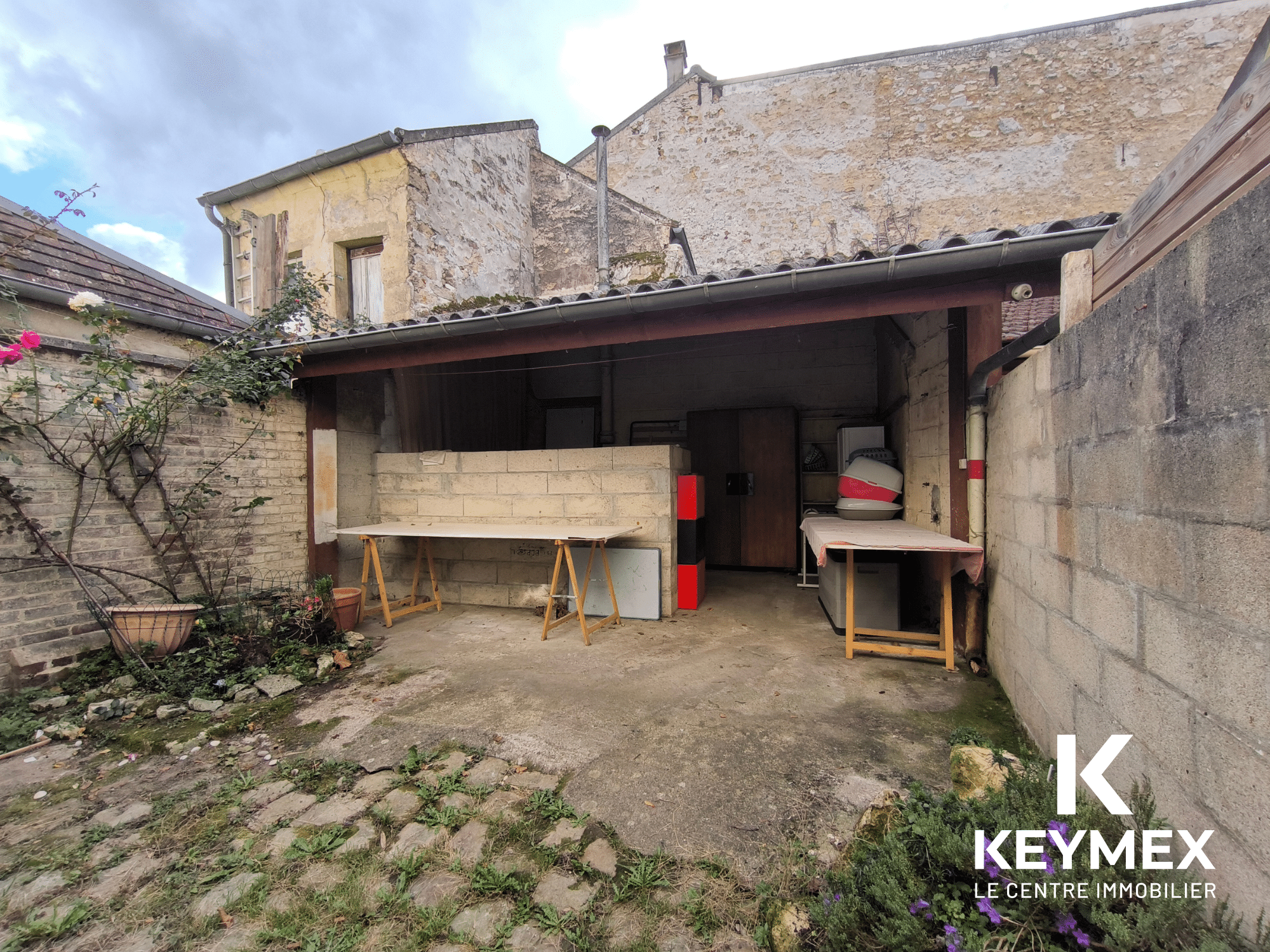 Garage vide avec murs en pierre, extérieur ancien.