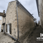 Maison en pierre dans une ruelle étroite.