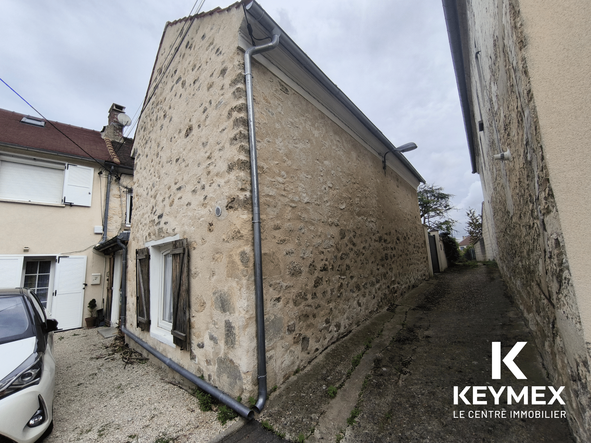 Maison en pierre dans une ruelle étroite.