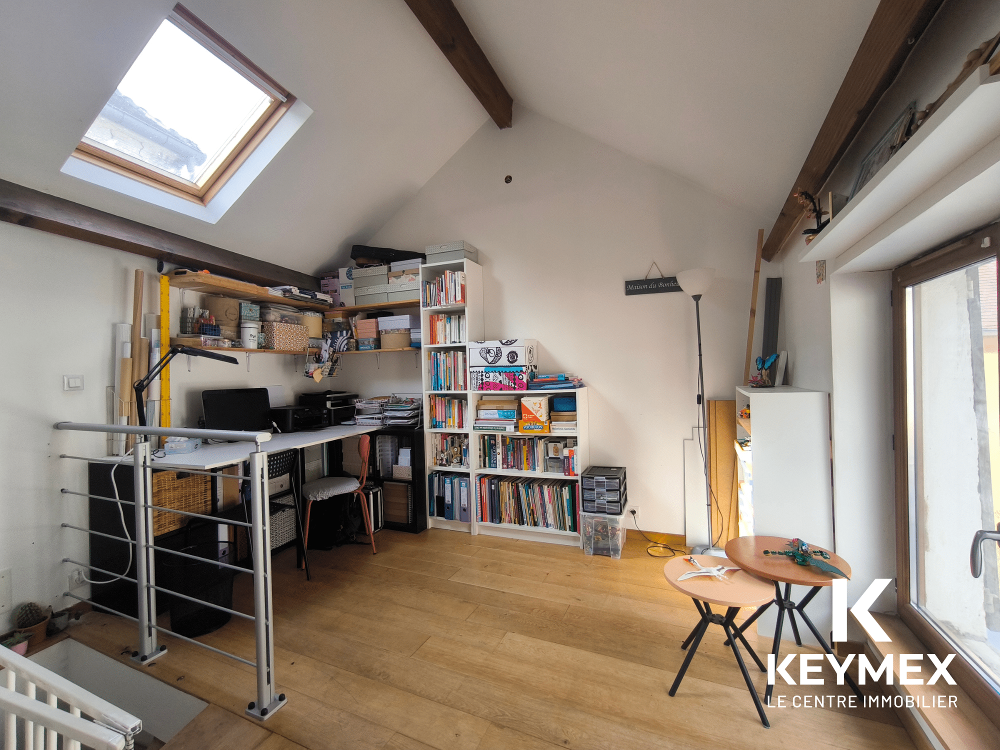 Bureau lumineux avec étagères et table d'appoint.