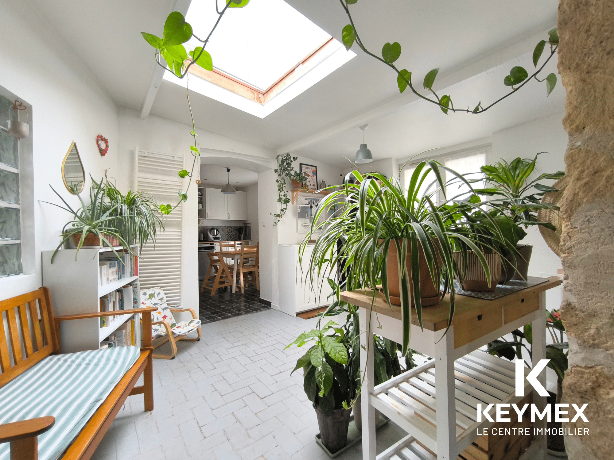 Cuisine lumineuse avec plantes et mobilier moderne.
