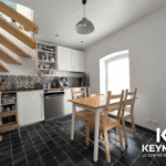 Cuisine moderne avec escalier en bois.