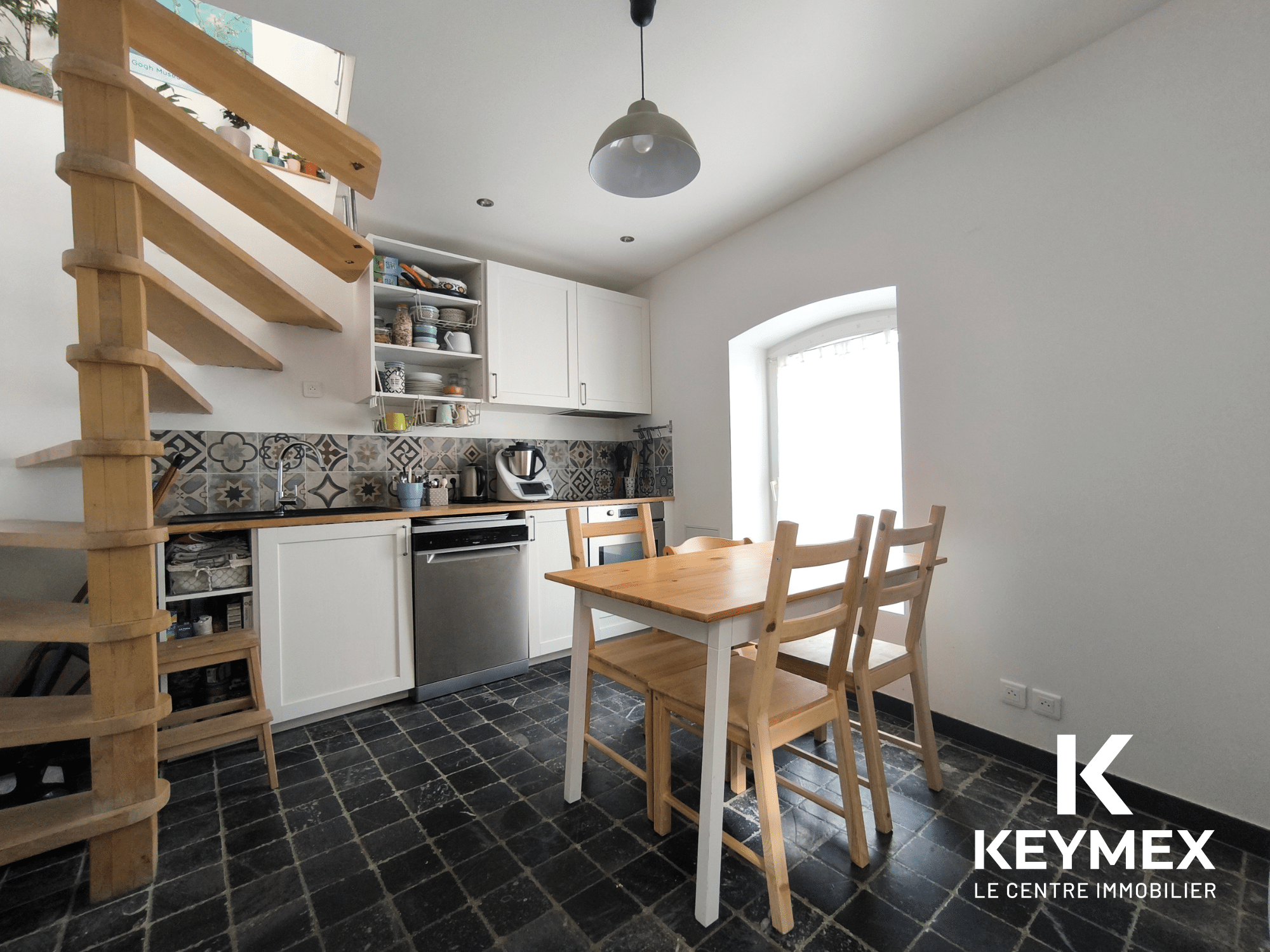 Cuisine moderne avec escalier en bois.